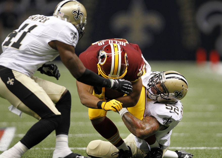 Washington Redskins running back Roy Helu (29)is tackled by New Orleans Saints linebacker Jonathan Casillas (52) and strong safety Roman Harper (41) in the first half of an NFL football game at the Mercedes-Benz Superdome in New Orleans, Sunday, Sept. 9, 2012. (AP Photo/Gerald Herbert)