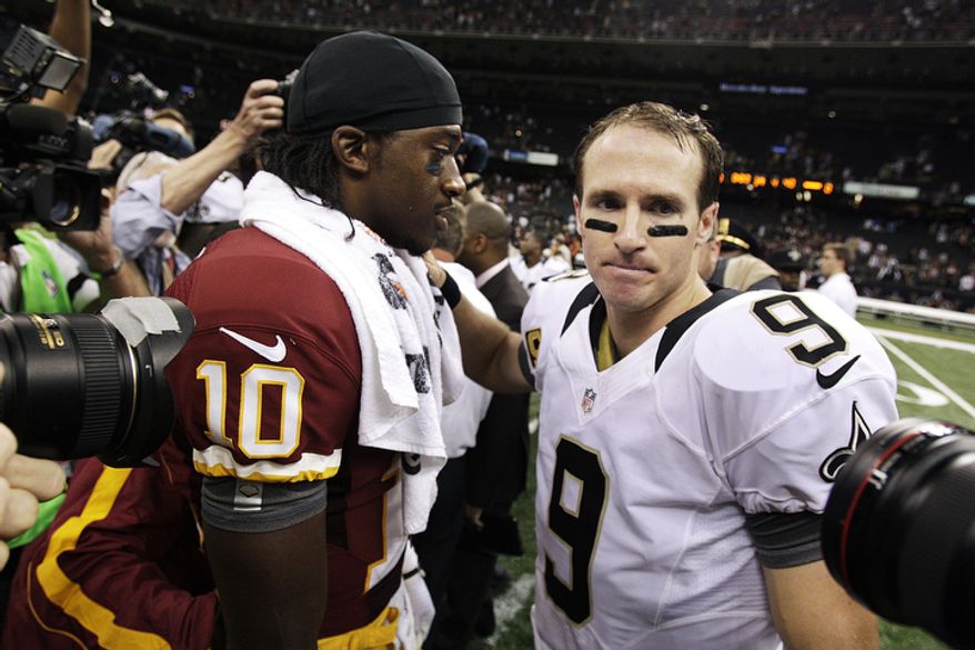 New Orleans Saints quarterback Drew Brees (9) greets Washington Redskins quarterback Robert Griffin III (10) after an NFL football game in New Orleans, Sunday, Sept. 9, 2012. The Redskins won 40-32. (AP Photo/Matthew Hinton)