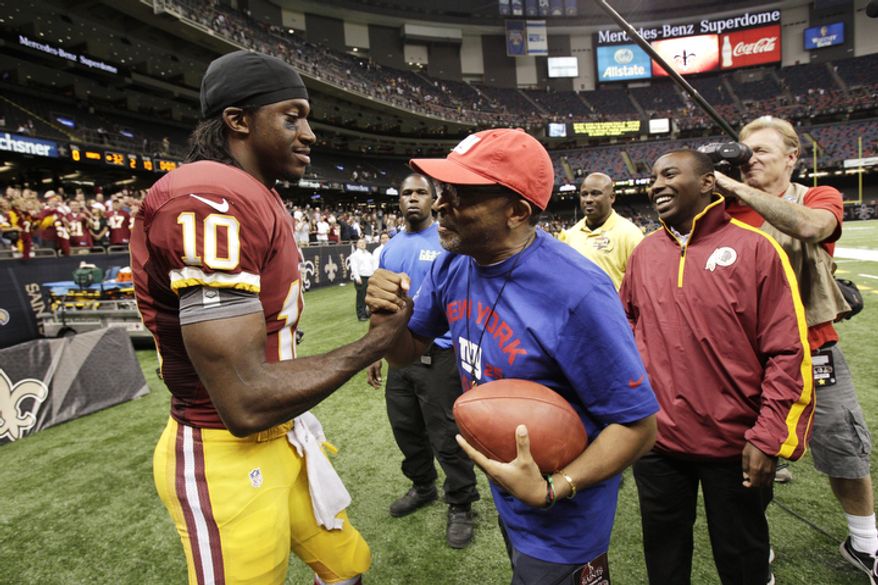 Washington Redskins quarterback Robert Griffin III (10) shakes hands with director Spike Lee after an NFL football game against the New Orleans Saints at the Mercedes-Benz Superdome in New Orleans, Sunday, Sept. 9, 2012. (AP Photo/Matthew Hinton)