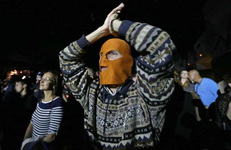 A masked spectator reacts Sept. 9, 2012, during a concert in St. Petersburg, Russia, organized to support jailed Pussy Riot musicians. A Moscow judge has sentenced each of three members of the provocative punk band to two years in prison on hooliganism charges following a trial that has drawn international outrage as an emblem of Russia's intolerance to dissent. (Associated Press)