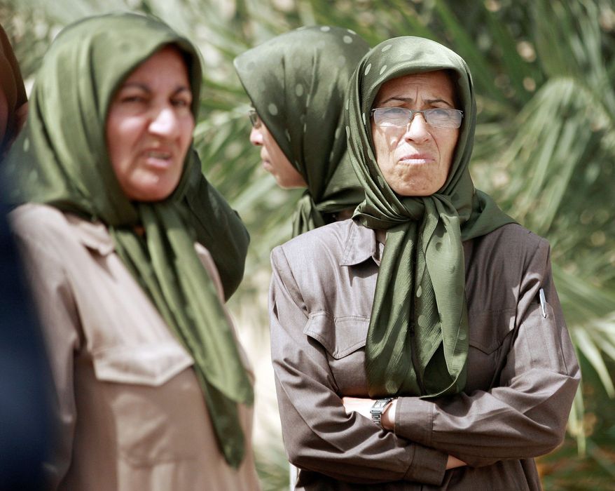 Women inside the Liberty refugee camp on the outskirts of Baghdad watch as foreign diplomats tour the facilities. The diplomats found the conditions better than what most refugees endure. (Associated Press)