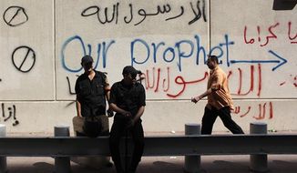 Egyptian soldiers stand guard in front of the U.S. embassy in Cairo, Egypt, Wednesday, Sept. 12, 2012. An Israeli filmmaker based in California went into hiding after his movie attacking Islam&#39;s prophet Muhammad sparked angry assaults by ultra-conservative Muslims in Egypt. Arabic on the wall reads, &quot;anyone but God&#39;s prophet.&quot; (AP Photo/Nasser Nasser)