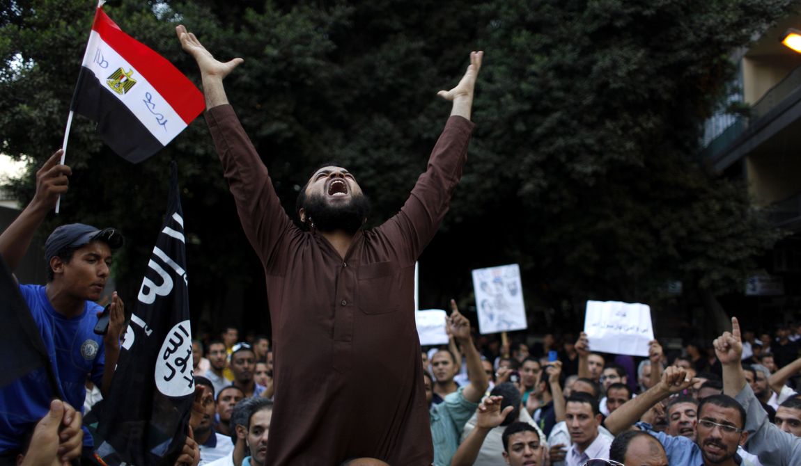 Egyptian protesters carry their national flag and a flag with Arabic that reads &quot;No God but Allah, and Mohammed is his prophet,&quot; and chant anti-U.S. slogans during a demonstration in front of the U.S. Embassy in Cairo on Sept. 12, 2012, as part of widespread anger across the Muslim world about a film ridiculing Islam&#x27;s prophet Muhammad. (Associated Press)