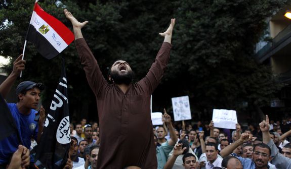 Egyptian protesters carry their national flag and a flag with Arabic that reads &quot;No God but Allah, and Mohammed is his prophet,&quot; and chant anti-U.S. slogans during a demonstration in front of the U.S. Embassy in Cairo on Sept. 12, 2012, as part of widespread anger across the Muslim world about a film ridiculing Islam&#39;s prophet Muhammad. (Associated Press)