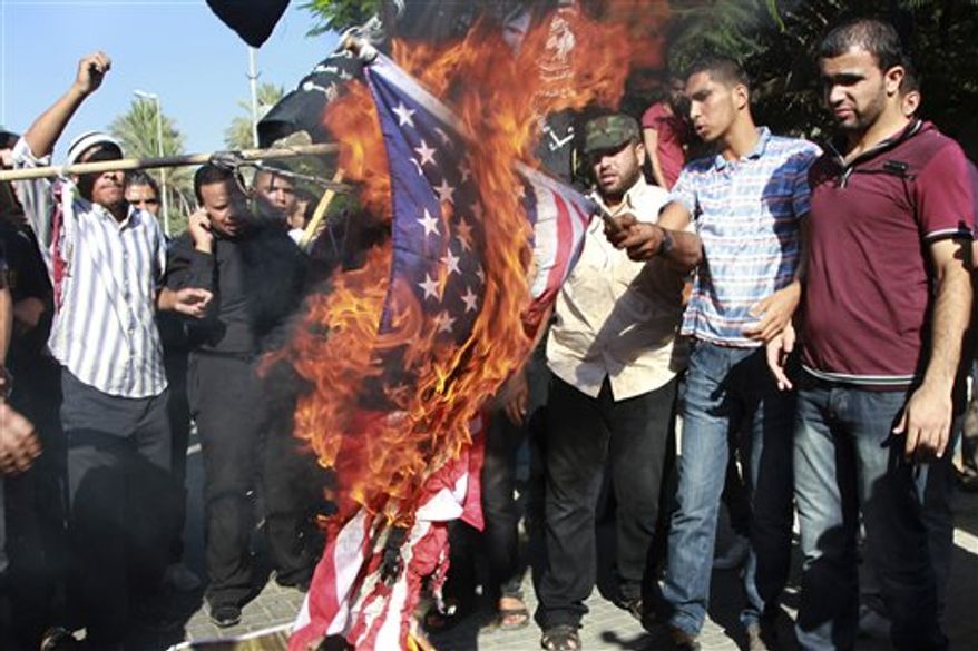 **FILE** Palestinians burn a U.S. flag during a protest against the movie, "Innocence of Muslims," near the United Nations office in Gaza City, Wednesday, Sept. 12, 2012. Muslim anger over perceived Western insults to Islam has exploded several times, most recently in Tuesday's attacks against U.S. diplomatic posts in the Middle East in which U.S. ambassador to Libya Chris Stevens and three other Americans were killed. (AP Photo/Adel Hana)