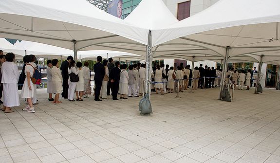 Mourners stand in line outside the Cheongpyeong Heaven and Earth Training Center complex outside of Seoul, Korea on Wednesday, Sept. 12, 2012 to pay tribute to the Rev. Sun Myung Moon. Traditional Korean funerals last three days, but the reverend&#39;s funeral will go for 13 days. It culminates Saturday, Sept. 15 with a SeongHwa Ceremony, which is considered the final farewell ceremony before burial. They are expecting some 30,000 people to attend. (Barbara L. Salisbury/The Washington Times)