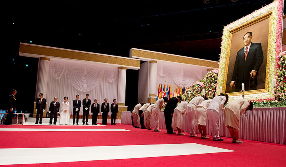 Family members of the Rev. Sun Myung Moon, including (in white) eldest daughter Ya-Jin stand at left waiting to greet mourners bowing at right after placing flowers on a table below a portrait of the reverend. The family members rotate throughout the day but are present from 8 a.m. to 10 p.m. to greet mourners as they come to the Cheongpyeong Heaven and Earth Training Center complex near Seoul, Korea to pay tribute to the late reverand, who founded the Unification Church. The official funeral service will be held this Saturday. This image was made Wednesday, Sept. 12, 2012. (Barbara L. Salisbury/The Washington Times)