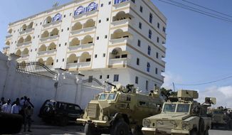 **FILE** African Union soldiers in armored personnel carriers keep guard Sept. 12, 2012, outside the Jazeera Hotel in Mogadishu, Somalia, the temporary home of new Somalian president Hassan Sheikh Mohamud, which was hit by two explosions earlier that day. The explosions came a day after the election of Mohamud, killing at least five people and wounded three others, witnesses and officials said. (Associated Press)