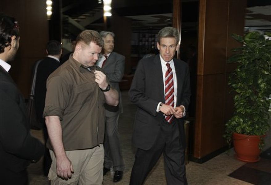 ** FILE ** In this photo taken Monday, April 11, 2011, then U.S. envoy Chris Stevens, right, is accompanied by an unidentified member of security personnel, left, as he attends meetings at the Tibesty Hotel where an African Union delegation was meeting with opposition leaders in Benghazi, Libya. (AP Photo/Ben Curtis)