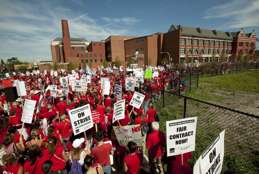 A large group of teachers marches past John Marshall Metropolitan High School on Wednesday, Sept. 12, 2012, in Chicago. (AP Photo/Sitthixay Ditthavong)