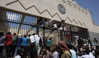 Yemeni demonstrators climb the gates of the U.S. Embassy in Sanaa, Yemen, on Thursday, Sept. 13, 2012, during a protest against a film ridiculing Islam&#x27;s Prophet Muhammad. (Associated Press) ** FILE **
