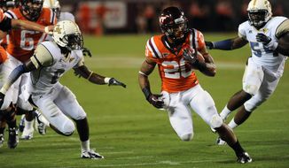 Virginia Tech running back Michael Holmes (20) looks for room against Georgia Tech&#39;s Rod Sweeting (6) and Quayshawn Nealy (54) during the first half of an NCAA college football game Monday, Sept. 3, at Lane Stadium, in Blacksburg, Va. Virginia Tech won in overtime,  20-17. (AP Photo/Don Petersen)
