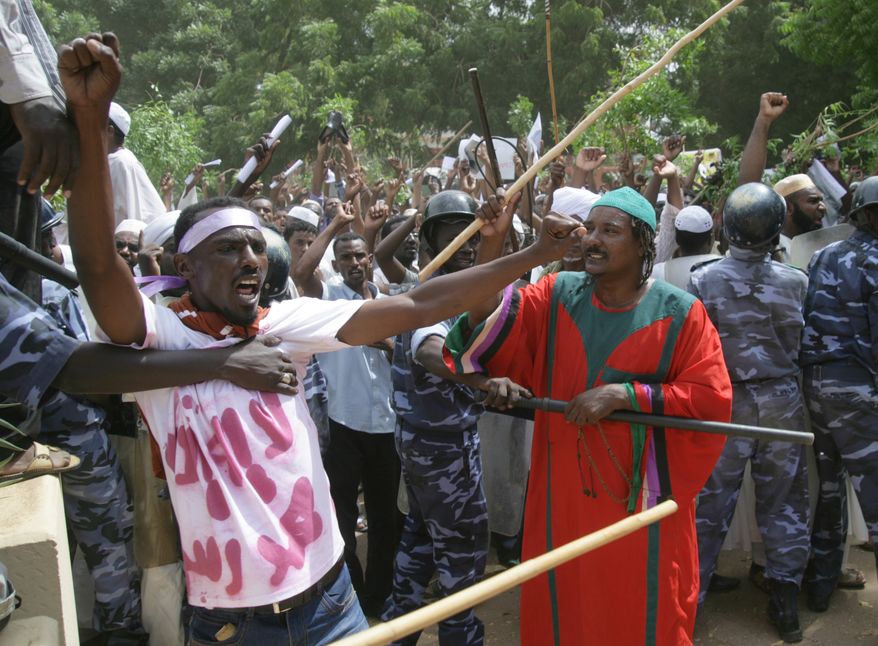 A Sudanese protester chants slogans as a cordon of police try to contain the crowd during a protest in Khartoum, Sudan, Friday, Sept. 14, 2012, as part of widespread anger across the Muslim world about a film ridiculing Islam's Prophet Muhammad. Germany's Foreign Minister says the country's embassy in the Sudanese capital of Khartoum has been stormed by protesters and set partially on fire. Minister Guido Westerwelle told reporters that the demonstrators are apparently protesting against an anti-Islam film produced in the United States that denigrates the Prophet Muhammad.(AP Photo/Abd Raouf)