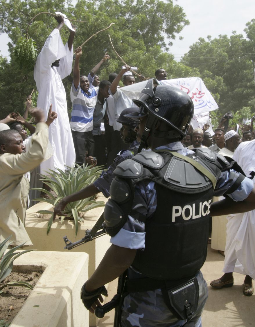 Sudanese protesters chant slogans as riot police stand guard during a protest in Khartoum, Sudan, Friday, Sept. 14, 2012, as part of widespread anger across the Muslim world about a film ridiculing Islam's Prophet Muhammad. Germany's Foreign Minister says the country's embassy in the Sudanese capital of Khartoum has been stormed by protesters and set partially on fire. Minister Guido Westerwelle told reporters that the demonstrators are apparently protesting against an anti-Islam film produced in the United States that denigrates the Prophet Muhammad.(AP Photo/Abd Raouf)