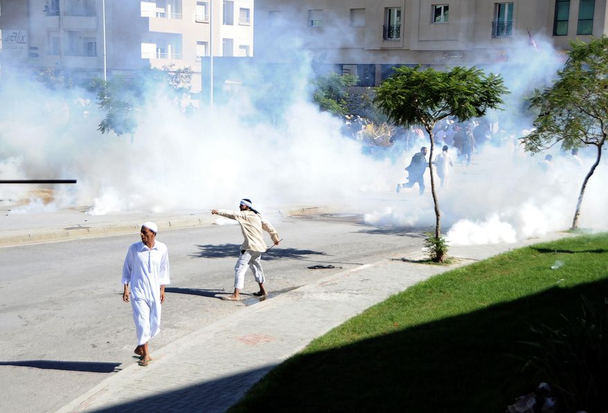 Demonstrators protest outside the U.S. embassy in Tunis on Sept. 14, 2012, as police responded with tear gas. Angry demonstrations against an anti-Islam film spread to their widest extent yet around the Middle East and other Muslim countries Friday, as protesters smashed into the German Embassy in the Sudanese capital and security forces in Egypt and Yemen fired tear gas and clashed with protesters to keep them away from U.S. embassies. (Associated Press)