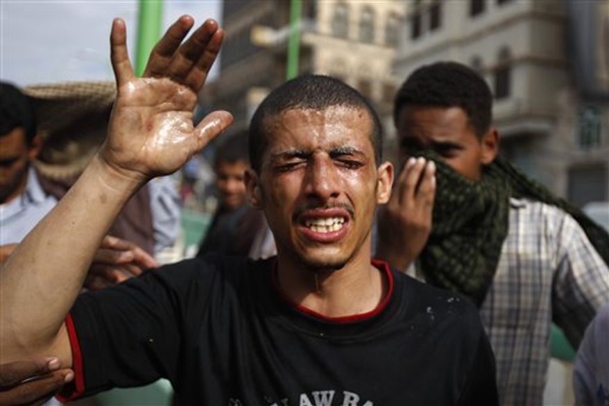 A protestor reacts from tear gas fired by riot police, unseen, near the U.S. Embassy during a protest about a film ridiculing Islam's Prophet Muhammad, in Sanaa, Yemen, Thursday, Sept. 13, 2012. (AP Photo/Hani Mohammed)