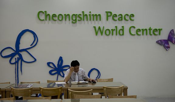 A staff member eats in the cafeteria of the Cheong Shim Peace World Center in Gapyeong, Korea before the Seonghwa, or ascension, ceremony for the late Rev. Sun Myung Moon on Saturday, Sept. 15, 2012. Although the funeral did not start until 10 a.m., mourners arrived hours in advance, so staff members had to be at the facility in the wee hours of the morning. (Barbara L. Salisbury/The Washington Times)