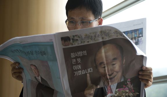 A man reads a paper that talks about the life of the late Rev. Sun Myung Moon in the stadium of the Cheong Shim Peace World Center in Gapyeong, Korea on Saturday, Sept. 15, 2012, the day of te reverend&#39;s funeral. (Barbara L. Salisbury/The Washington Times)