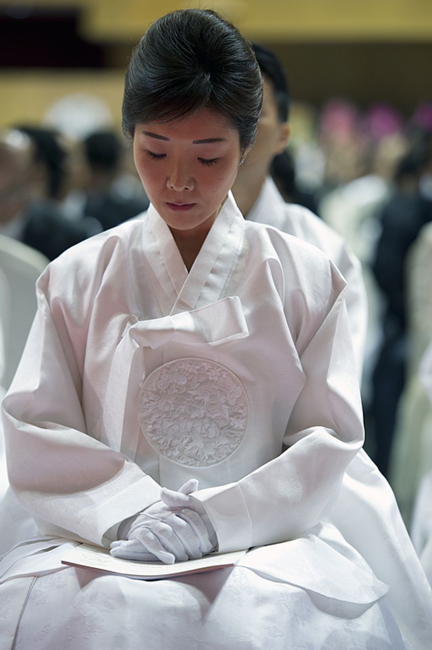 Sun Jun Moon, daughter of the late Rev. Sun Myung Moon, sits with her head down during her father&#x27;s funeral at the Cheong Shim Peace World Center in Gapyeong, Korea on Saturday, Sept. 15, 2012. (Barbara L. Salisbury/The Washington Times)