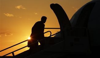 Republican presidential candidate and former Massachusetts Gov. Mitt Romney is seen in silhouette as he boards his campaign charter plane while the sun sets in Cleveland, Ohio, Friday, Sept. 14, 2012, after holding a campaign rally and fundraising events. (AP Photo/Charles Dharapak)