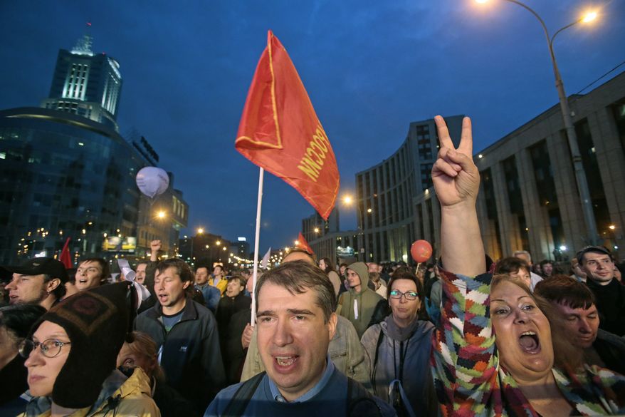 Opposition protesters react while listening to speakers during a rally in Moscow on Saturday, Sept. 15, 2012. The first major protest against President Vladimir Putin after a summer lull drew tens of thousands of people, determined to show that opposition sentiment remains strong despite Kremlin efforts to muzzle dissent. (AP Photo/Mikhail Metzel)