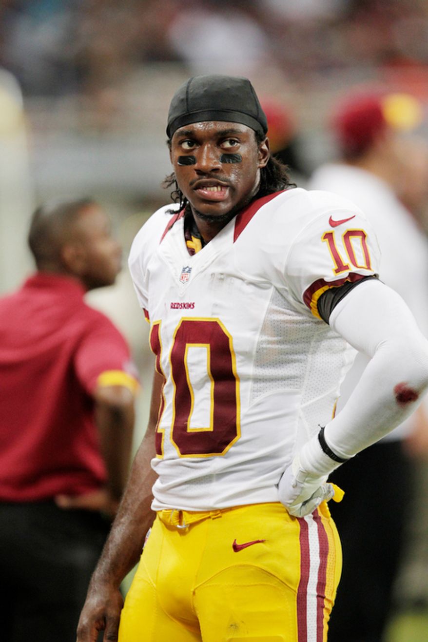 Washington Redskins quarterback Robert Griffin III stands on the sidelines during the fourth quarter of an NFL football game against the St. Louis Rams. The Rams won 31-28. (AP Photo/Tom Gannam)