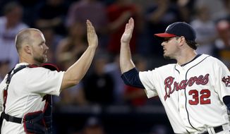 Atlanta Braves relief pitcher Chad Durbin, right, high-fives teammate David Ross, after the Braves defeated the Washington Nationals 5-1 in a baseball game Sunday, Sept. 16, 2012, in Atlanta. (AP Photo/David Goldman)