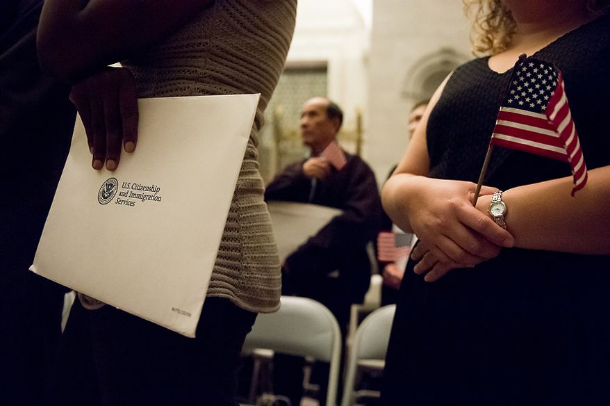 Petitioners stand to be sworn in as U.S. citizens on Sept. 17, 2012, at the National Archives Building in Washington, during a naturalization ceremony to commemorate the 225th anniversary of the signing of the U.S. Constitution. (Andrew Harnik/The Washington Times)