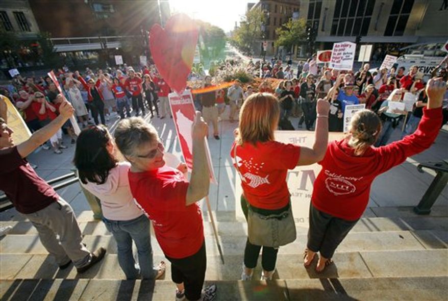 ** FILE ** In this Sept. 14, 2012 photo Madison teachers hold a unity rally for striking Chicago teachers at the Wisconsin state Capitol in Madison, Wis. Wisconsin's attorney general planned to ask a judge Tuesday, Sept. 18, 2012, to put on hold his decision issued last week repealing major parts of Gov. Scott Walker's law effectively ending collective bargaining for most state workers. (AP Photo/Wisconsin State Journal, M.P. King, File)