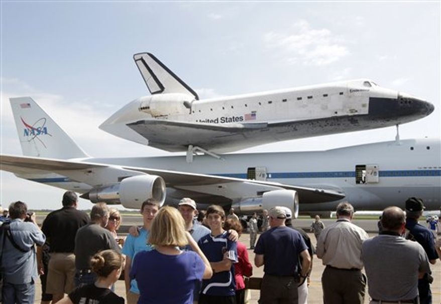 A large crowd takes photographs of the Space Shuttle Endeavour sitting atop NASA's 747 Shuttle Carrier Aircraft at Ellington Field in Houston on Wednesday, Sept. 19, 2012. Endeavour will spend the night in Houston before continuing its journey from the Kennedy Space Center in Florida to the California Science Center in Los Angeles where it will be on permanent display. (AP Photo/The Galveston County Daily News, Kevin M. Cox)