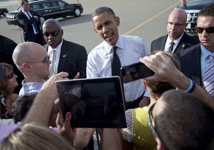President Obama greets people Sept. 20, 2012, on the tarmac as he arrives on Air Force One at Tampa International Airport in Tampa. (Associated Press)