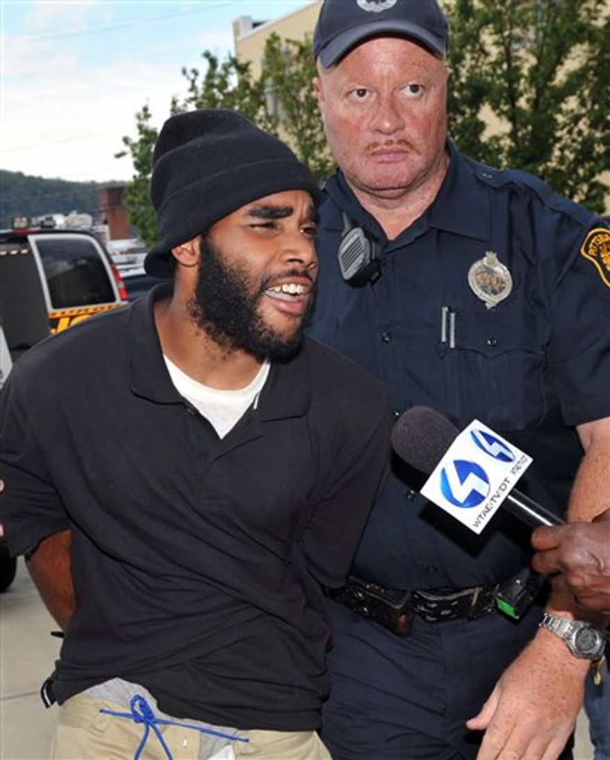 Klein Michael Thaxton, left, is lead into Pittsburgh Police headquarters after being apprehended without incident at Three Gateway Center in Pittsburgh, Friday Sept. 21, 2012. Thaxton held a businessman hostage inside the office building for more than five hours Friday, posting Facebook updates during the standoff, and surrendered to authorities without incident, police said. (AP Photo/The Tribune-Review, JC Schisler)