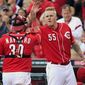 Cincinnati Reds starting pitcher Mat Latos (55) high-fives catcher Dioner Navarro at the end of the eighth inning of a baseball game against the Los Angeles Dodgers, Saturday, Sept. 22, 2012, in Cincinnati. Cincinnati won 6-0 to clinch the National League Central Division. (AP Photo/Al Behrman)