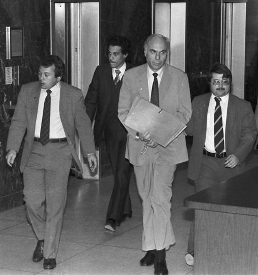 ** FILE ** In this Jan. 22, 1983, file photo, ex-CIA agent Edwin Wilson, center, leaves federal court after a day of jury selection accompanied by U.S. Marshals in Houston. Wilson, who was branded a traitor and convicted of shipping arms to Libya but whose conviction was later overturned after he served 22 years in prison, died on Sept. 10, 2012. He was 84. (AP Photo/File)