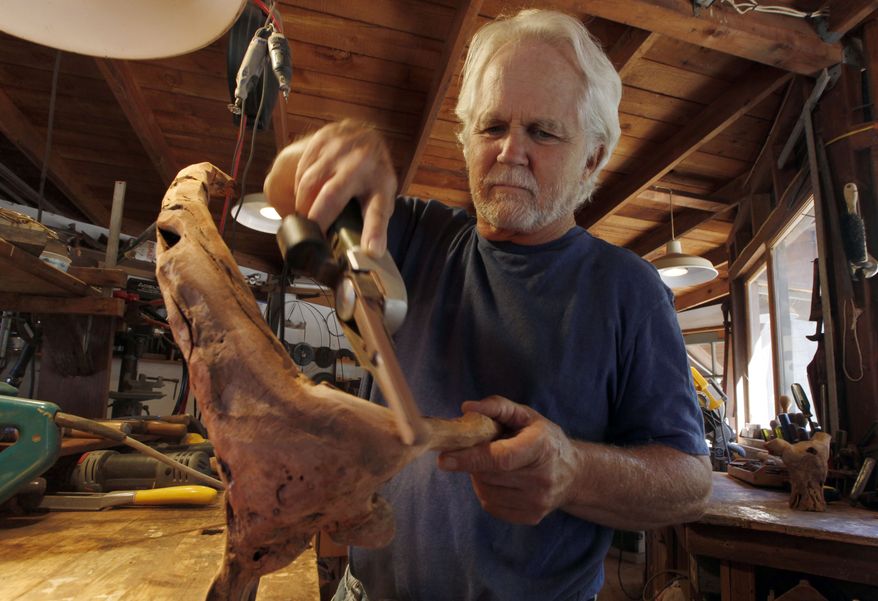 Actor, director and artist Tony Dow works on an abstract wood sculpture at his home studio in the Topanga area of Los Angeles. (AP Photo/Reed Saxon)