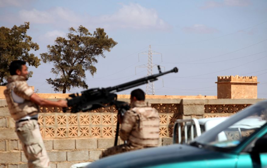 Soldiers from the Libyan National Army prepare to enter the Rafallah al-sahati Islamic Militia Brigade's compound, seen behind the wall, in Benghazi, Libya, on Saturday, Sept. 22, 2012. (AP Photo/Mohammad Hannon)