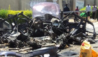 The remains of a car used in a suicide bombing sit outside a church in Bauchi, Nigeria, on Sunday, Sept. 23, 2012. The attack killed two people and wounded another 45, officials said. (AP Photo)