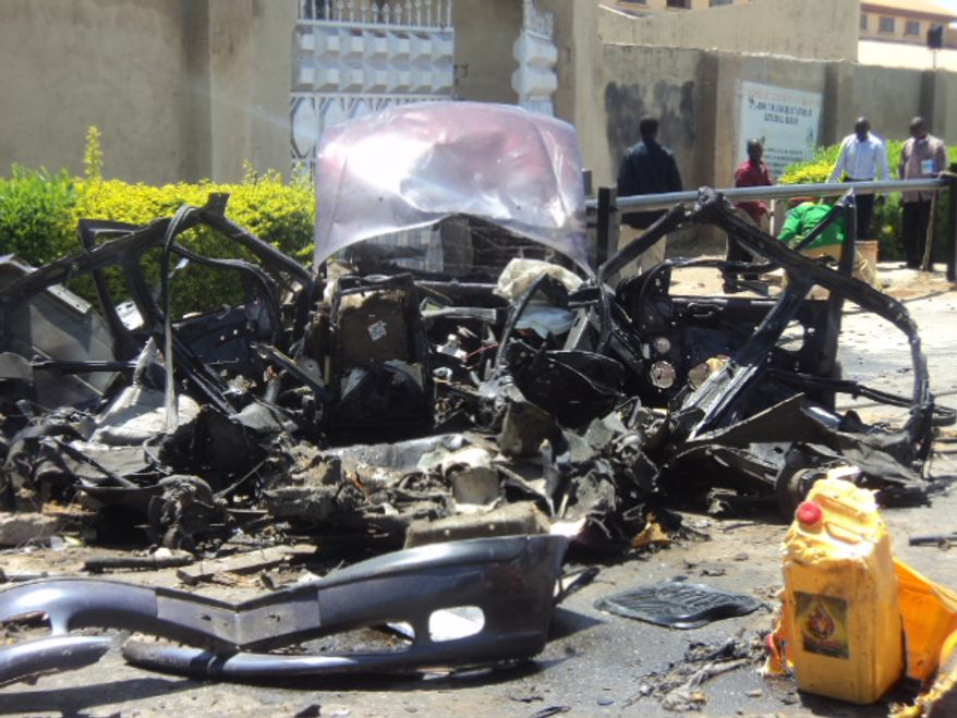 The remains of a car used in a suicide bombing sit outside a church in Bauchi, Nigeria, on Sunday, Sept. 23, 2012. The attack killed two people and wounded another 45, officials said. (AP Photo)