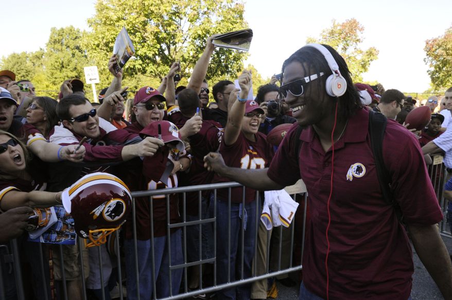 Washington Redskins quarterback Robert Griffin III signs autographs for the fans as he arrives to FedEx Field, Landover, Md., Sep. 23, 2012. (Preston Keres/Special to The Washington Times)