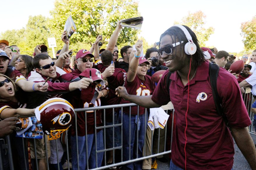 Washington Redskins quarterback Robert Griffin III signs autographs for the fans as he arrives to FedEx Field, Landover, Md., Sep. 23, 2012. (Preston Keres/Special to The Washington Times)