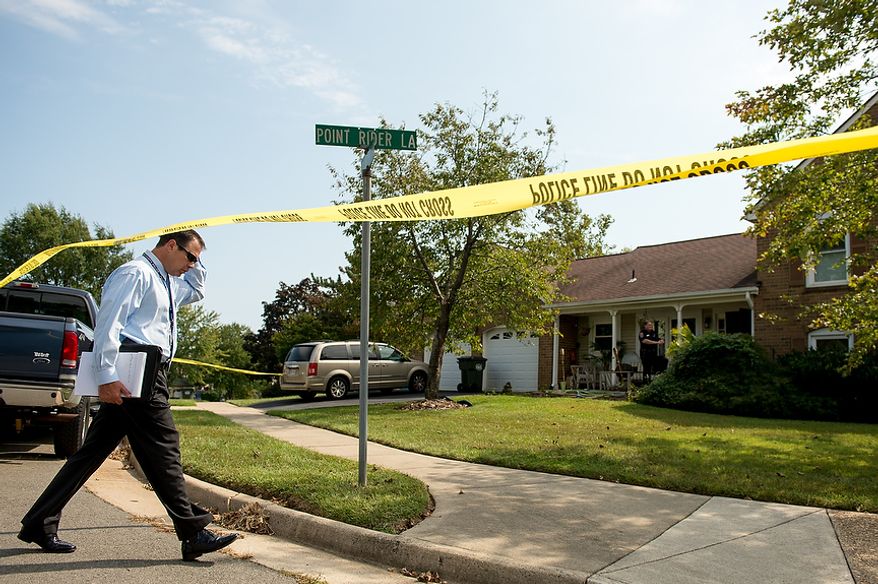 Fairfax police officers investigate the death of four family members discovered around 12pm after individuals had failed to show up to work, Herndon, Va., Tuesday, September 25, 2012. (Andrew Harnik/The Washington Times)