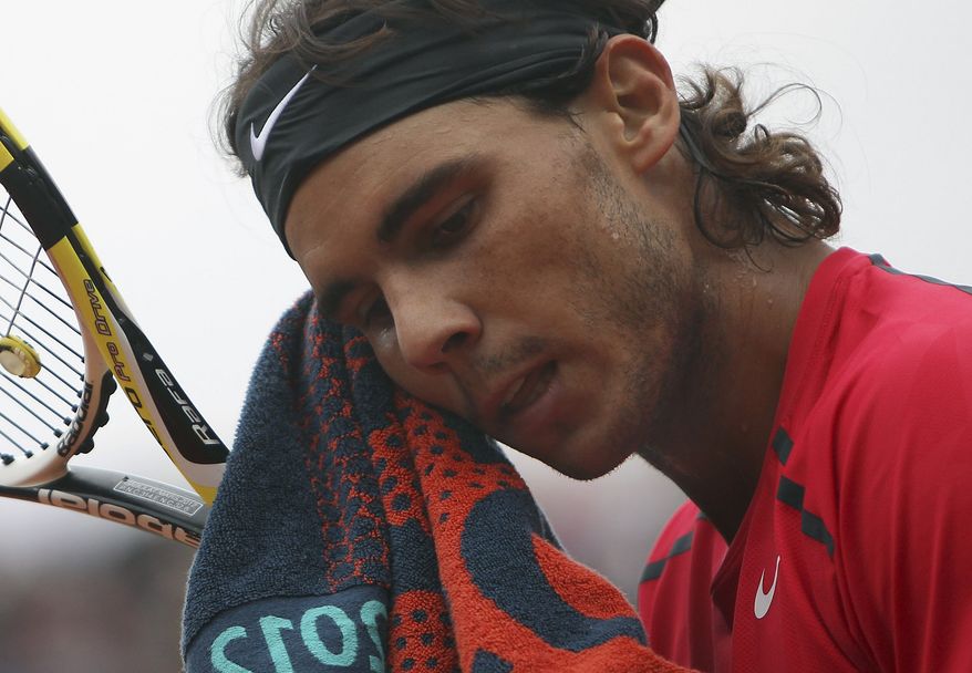 FILE - This June 10, 2012 file photo shows Rafael Nadal wiping his face as he plays Serbia's Novak Djokovic during their men's final match in the French Open tennis tournament at Roland Garros stadium in Paris. Nadal still has no timetable for his return from a knee injury. The Spaniard hasn't played since losing in the second round of Wimbledon in June to little-known Lukas Rosol. (AP Photo/David Vincent, File)