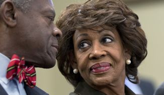 Rep. Maxine Waters, California Democrat, smiles Sept. 21, 2012, at her husband, Sidney Williams (left), during a House Ethics Committee hearing on Capitol Hill in Washington after learning she had been cleared of allegations that she steered a $12 million federal bailout to a bank where her husband owns stock. (Associated Press)