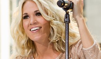 Country singer Carrie Underwood gave a 12-year-old boy his first kiss on stage in front of thousands at a concert in Louisville, Ky., over the weekend. (Associated Press)