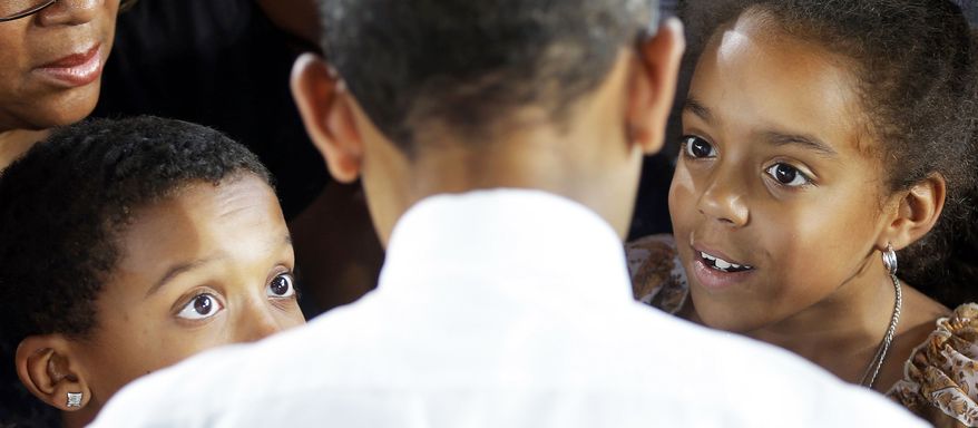 President Obama stops to talk with two young supporters at a campaign event at Farm Bureau Live in Virginia Beach. Mr. Obama carried Virginia in 2008 and is fighting to do the same this year. (Associated Press)