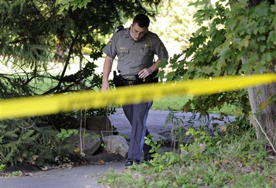 State Trooper Matt Losh emerges from the backyard of a home on Meeting House Hill Circle in New Fairfield, Conn., where a fatal shooting took place, Thursday, Sept. 27, 2012. A Connecticut man fatally shot a masked teenager in self-defense during what appeared to be an attempted burglary early Thursday morning, then discovered that he had killed his son, state police said. (AP Photo/The News-Times, Carol Kaliff)