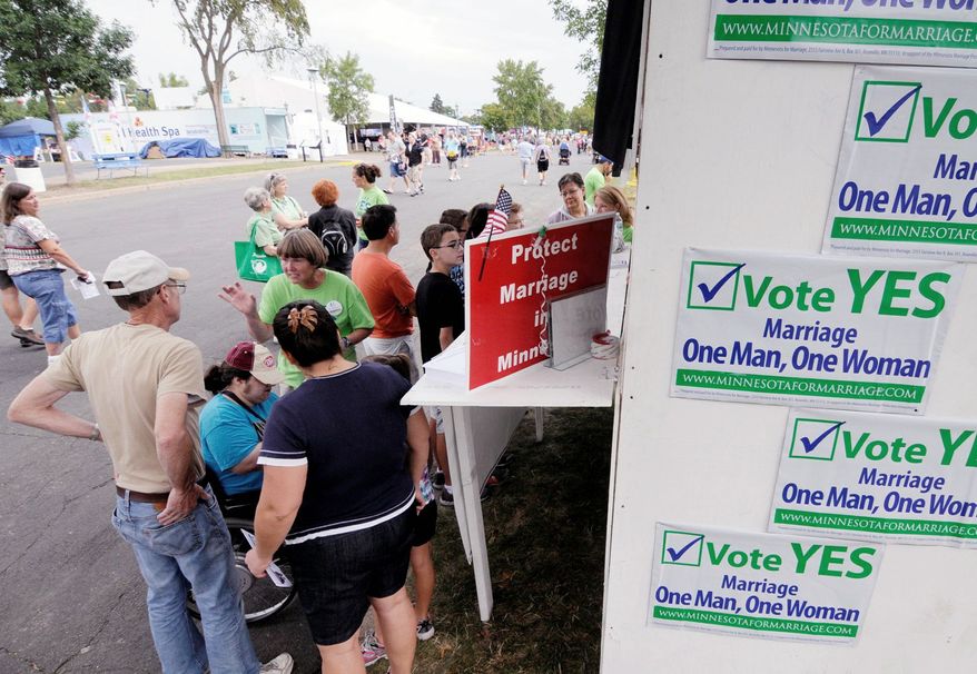 Visitors to a Minnesota State Fair booth staffed by supporters of a state constitutional amendment banning gay marriage chat with a volunteer in late August in Falcon Heights, Minn. Gay-marriage backers, who are seeking to defeat the initiative, are likely to far outspend proponents, though the most recent polls show the referendum narrowly ahead. (Associated Press)