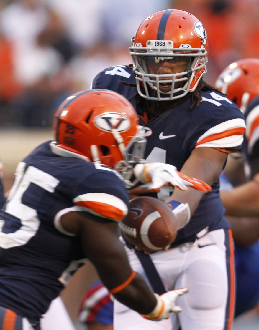 Virginia quarterback Phillip Sims (14) hands the ball off to Virginia running back Kevin Parks (25) during the second half of the NCAA college football game at Scott stadium in Charlottesville, Va., Saturday, Sept. 29, 2012. Sims was substituted after Virginia quarterback Michael Rocco (16) threw three interceptions. Louisiana Tech won the game 44-38. (AP Photo/Steve Helber)
