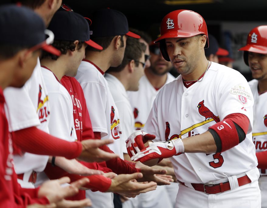 St. Louis Cardinals' Carlos Beltran (3) is congratulated by teammates in the dugout after hitting a two-run home run during the fourth inning of a baseball game against the Washington Nationals, Sunday, Sept. 30, 2012, in St. Louis. The home run was Beltran's second of the day. (AP Photo/Jeff Roberson)