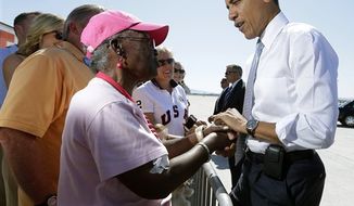 President Obama greets supporters on the tarmac upon his arrival at McCarran International airport, Sunday, Sept. 30, 2012 in Las Vegas. Obama traveled to Las Vegas for a campaign rally then will be staying in Henderson, Nev., to prepare for the first Presidential debate. (AP Photo/Pablo Martinez Monsivais)